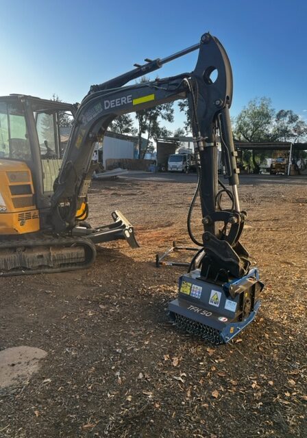 An excavator is sitting on a dirt lot.